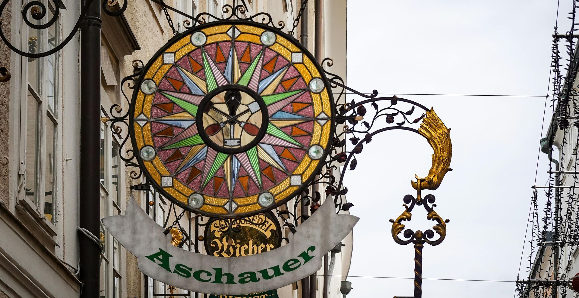 Ornate custom wrought-iron and stained-glass hanging shop sign