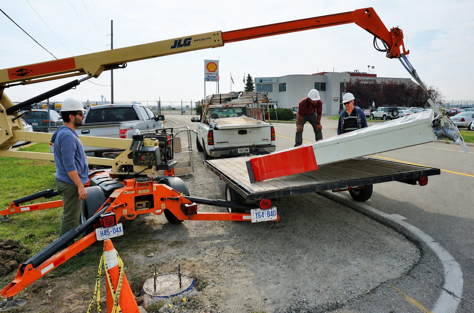 Installation crew unloading and staging a wholesale sign panel with a boom lift before mounting